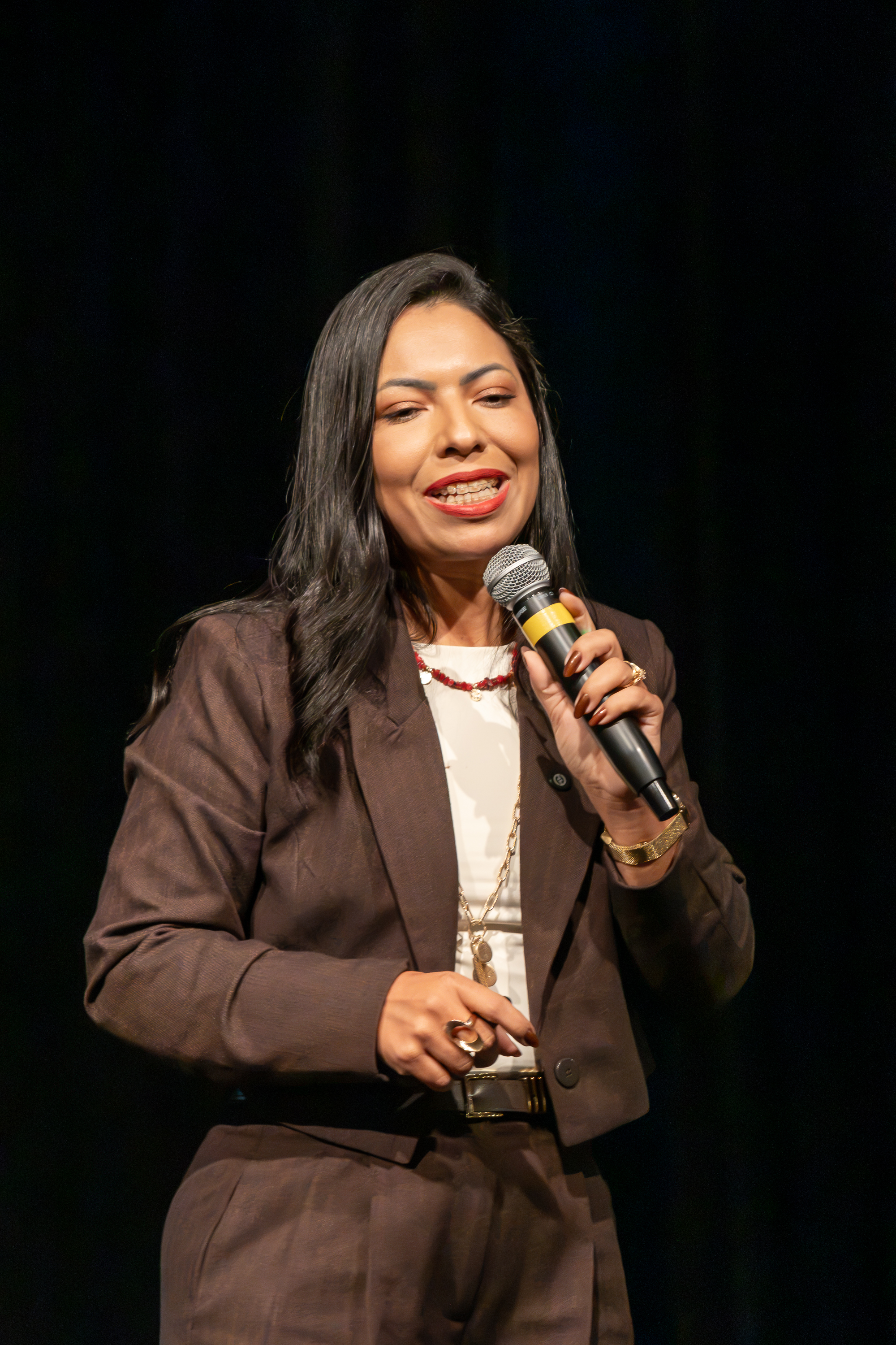 Jamilla Salviano falando ao microfone em uma palestra